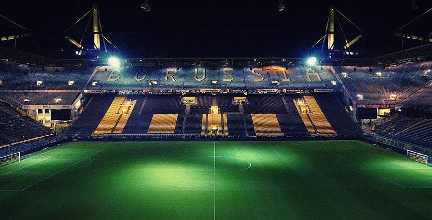 Empty Borussia Dortmund Stadium at Night with Floodlights