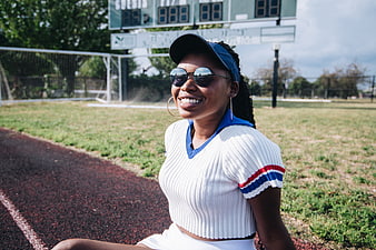 Smiling Black Woman in Sporty Outfit Sitting on Track