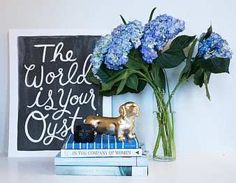Blue hydrangeas, golden dog figurine, and books with inspirational quote