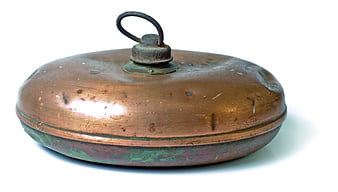 Antique copper container with lid and handle on white background