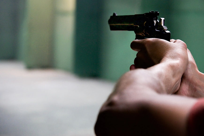 Hands Holding Black Revolver Pistol