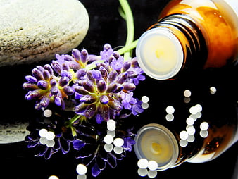 Lavender Flowers and Essential Oil Bottle on Black Background