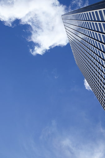 Low angle view of modern skyscraper against blue sky