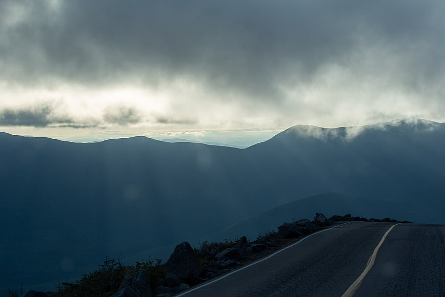 Winding Mountain Road Through Misty Clouds and Fog
