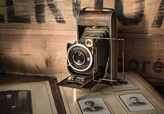 Vintage folding camera on antique photo album