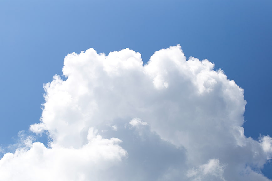 Fluffy white cumulus cloud against clear blue sky