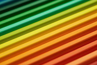 Close-up of colorful pencils arranged in a rainbow gradient