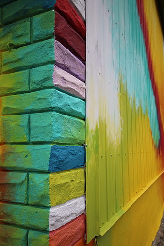 Colorful painted brick wall corner with vibrant street art