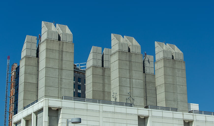 Concrete ventilation towers on urban rooftop against blue sky