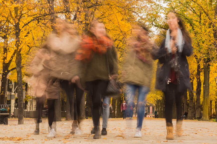 Motion blur of happy women walking in autumn park