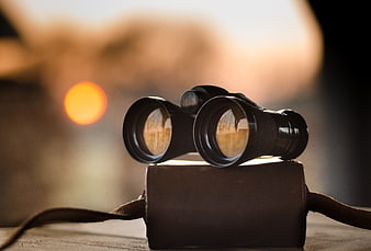 Vintage Binoculars on Leather Case with Sunset Bokeh Background