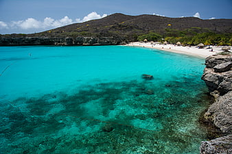 Turquoise Lagoon Beach with White Sand and Rocky Hills