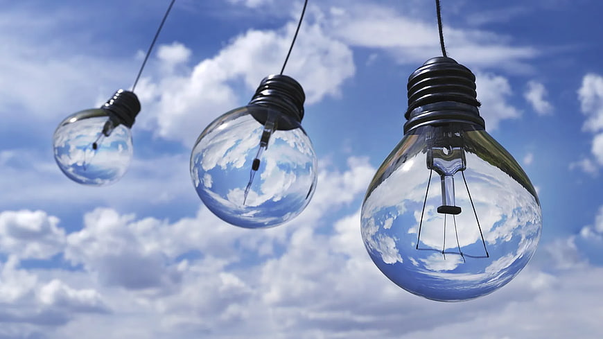 Three Hanging Light Bulbs Against Blue Sky