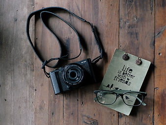 Vintage camera, notebook, and glasses on rustic wooden table