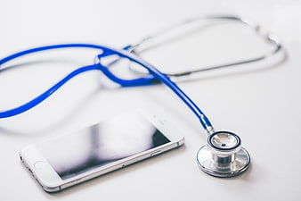 Blue stethoscope and smartphone on white background