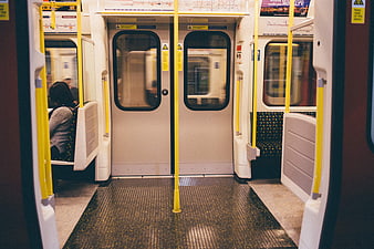 Interior of a subway train with yellow poles and doors