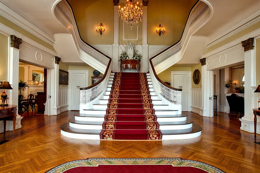Grand foyer with red carpet staircase and chandelier