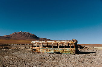 Abandoned Rusty Bus in Desert Landscape with Mountain