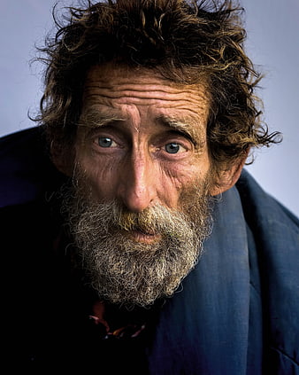 Close-up portrait of elderly man with wild curly hair and beard