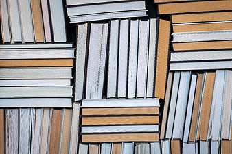 Top View of Stacked Books with Orange and White Spines
