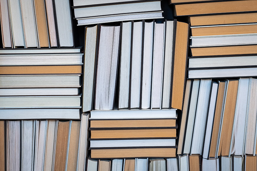 Top View of Stacked Books with Orange and White Spines