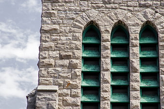 Old Stone Church Facade with Green Arched Shutters