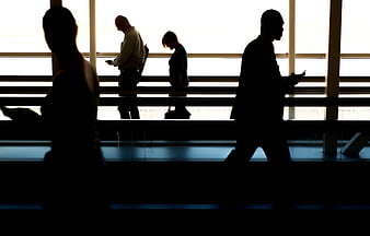 Silhouettes of business travelers walking in airport terminal