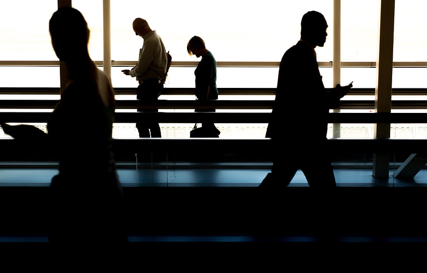 Silhouettes of business travelers walking in airport terminal