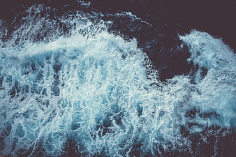 Aerial view of crashing ocean waves with white foam