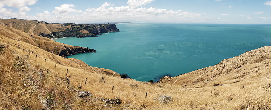 Panoramic coastal landscape with golden hills and turquoise ocean