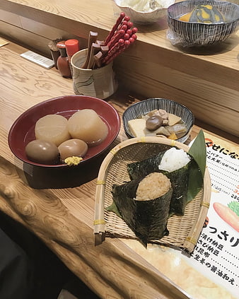 Traditional Japanese Bento with Onigiri and Oden on Wooden Counter