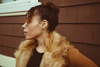 Profile portrait of stylish woman with curly hair and fur coat