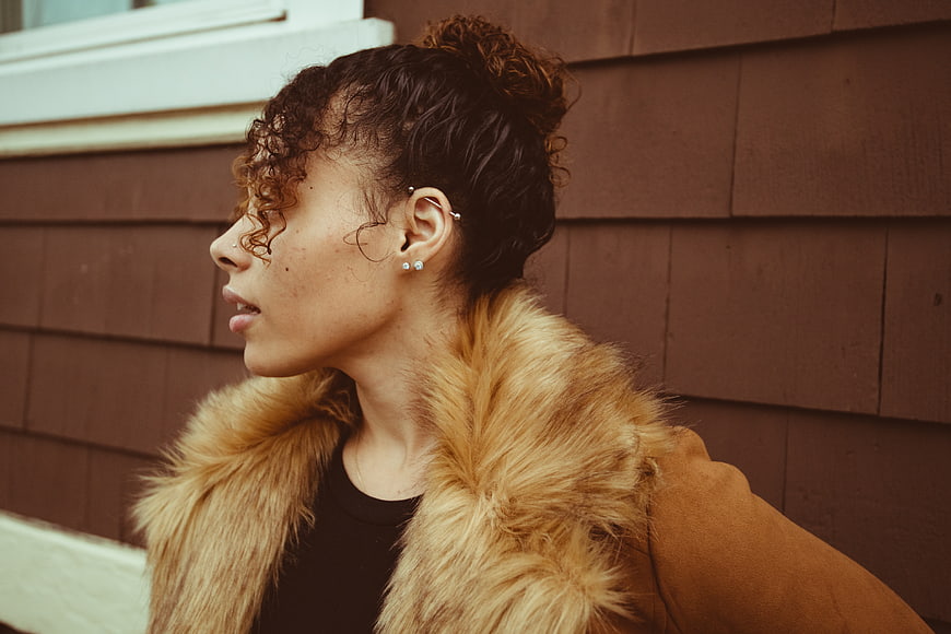 Profile portrait of stylish woman with curly hair and fur coat