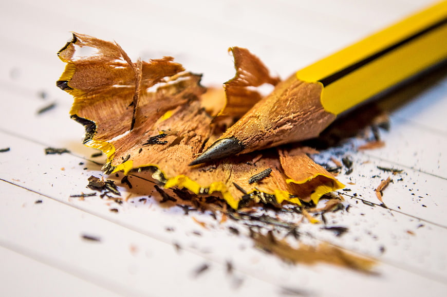 Close-up of yellow pencil with shavings on lined paper