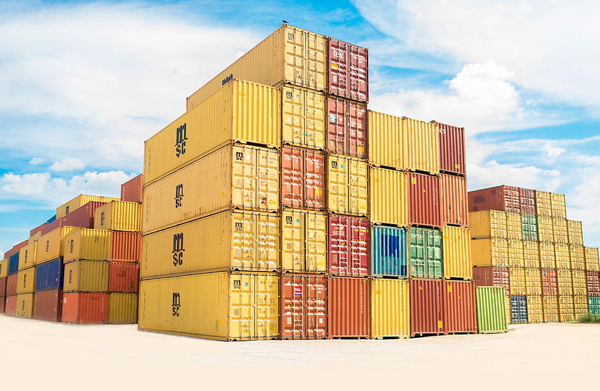 Stacked Shipping Containers in Cargo Yard Under Blue Sky