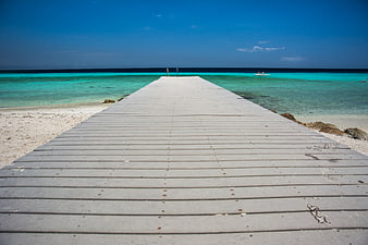 Wooden pier extending into turquoise Caribbean ocean water