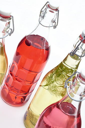 Colorful infused spirits in glass swing-top bottles
