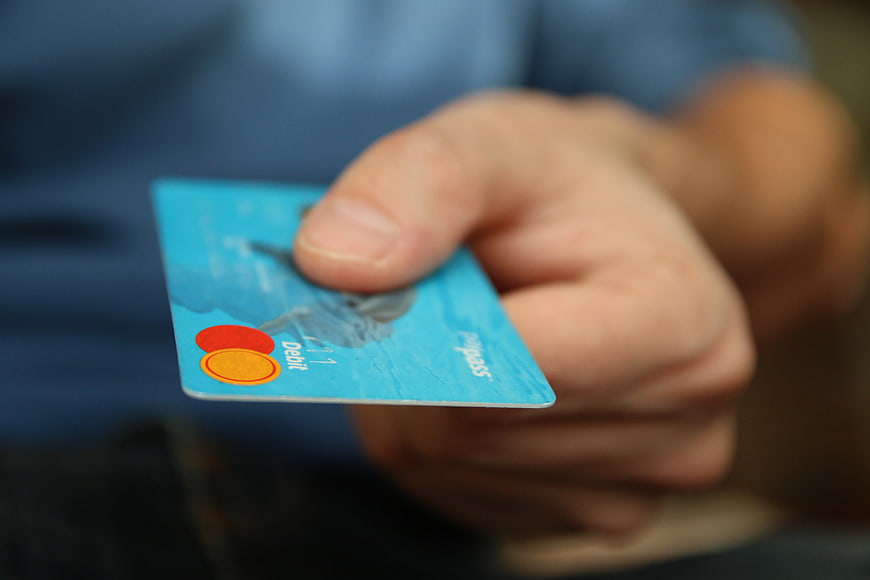 Hand holding blue Mastercard debit card close up