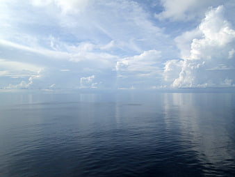 Serene Ocean Horizon with Cloud Reflections and Blue Sky