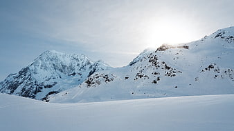 Snowy Mountain Peaks with Sunlight and Clear Sky