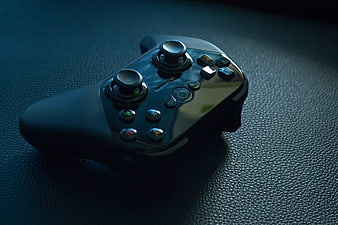 Black Wireless Game Controller on Textured Leather Surface