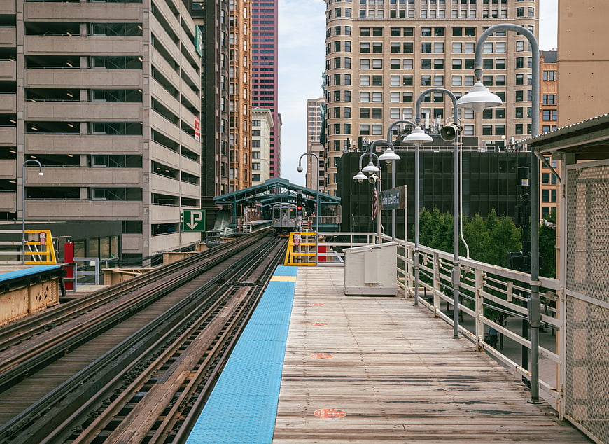 Empty elevated train platform with tracks and city buildings