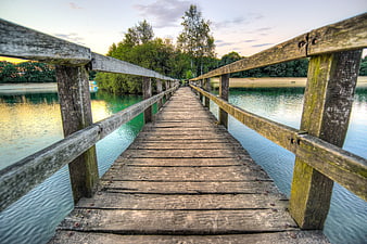 Wooden pier extending over calm lake at sunset