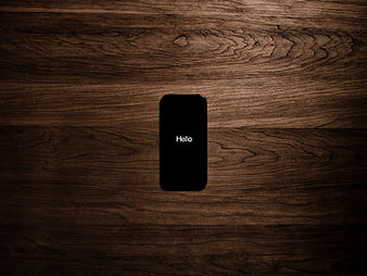 Smartphone with Hello text on dark wood background
