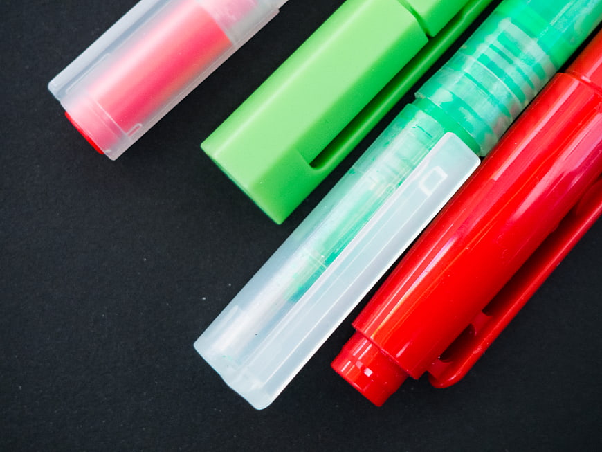 Colorful highlighters and markers on black background