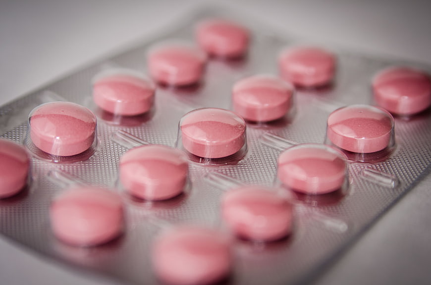 Close-up of pink round pills in blister pack