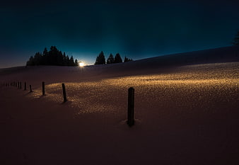 Snowy Winter Landscape with Wooden Fence Posts at Dusk