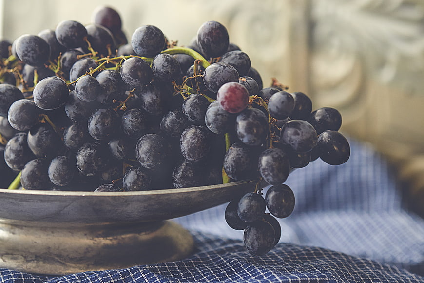 Ripe Purple Grapes in Rustic Silver Bowl on Blue Cloth