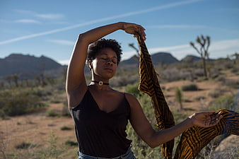 Woman meditating with scarf in desert landscape