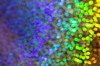 Abstract colorful bokeh lights background with purple and green glow